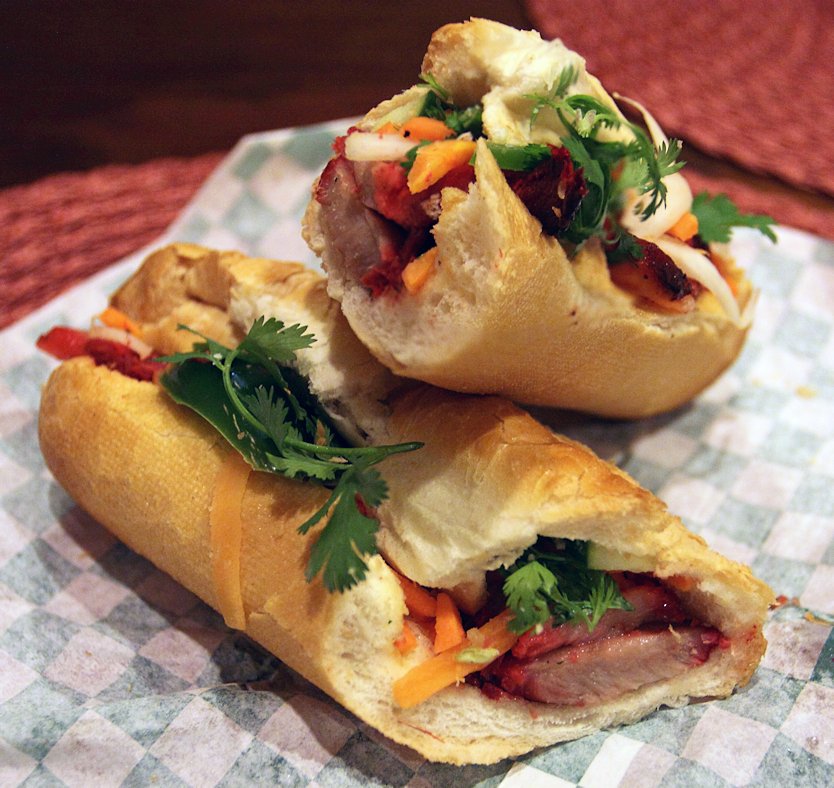 Banh mi baguette sandwich with grilled pork and herbs