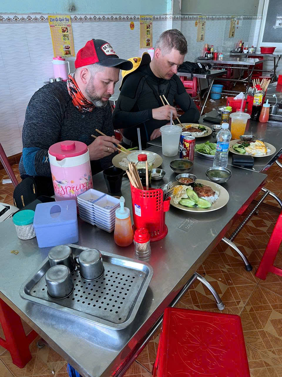 Two riders eating broken rice at a local eatery
