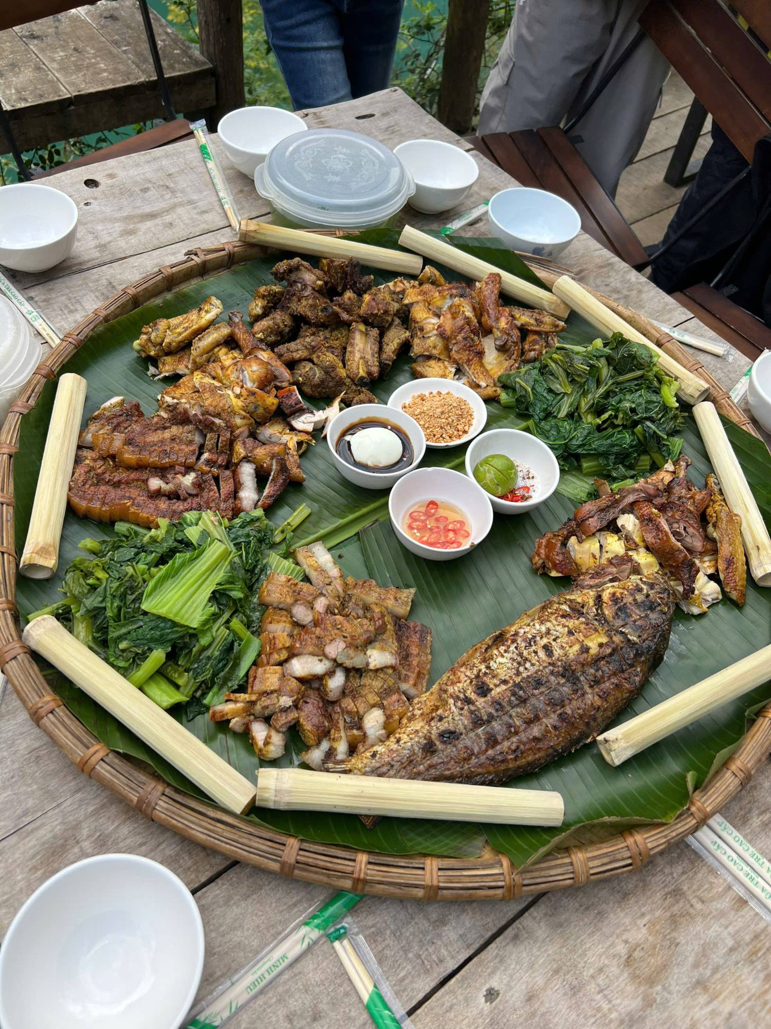 Grilled fish, pork and chicken with bamboo rice on a banana leaf
