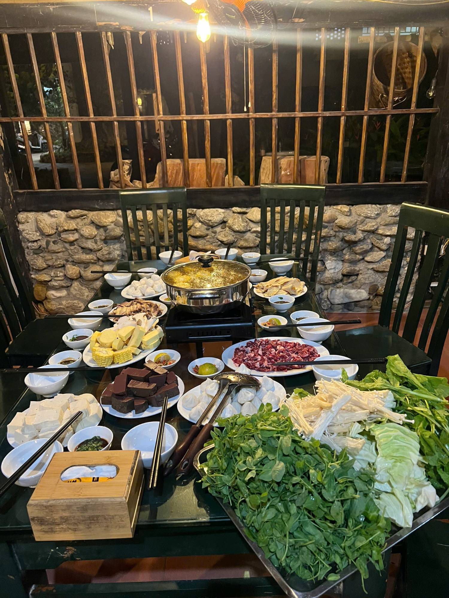 Hotpot dinner laid out with beef, tofu, dumplings and fresh greens