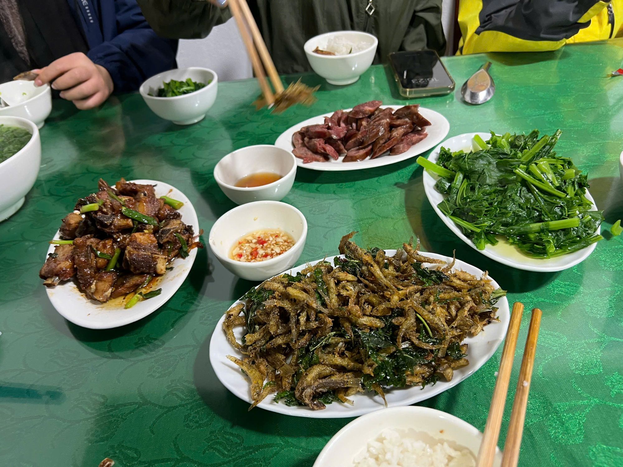 Northern home-style meal of fried fish, braised pork, sausage and greens