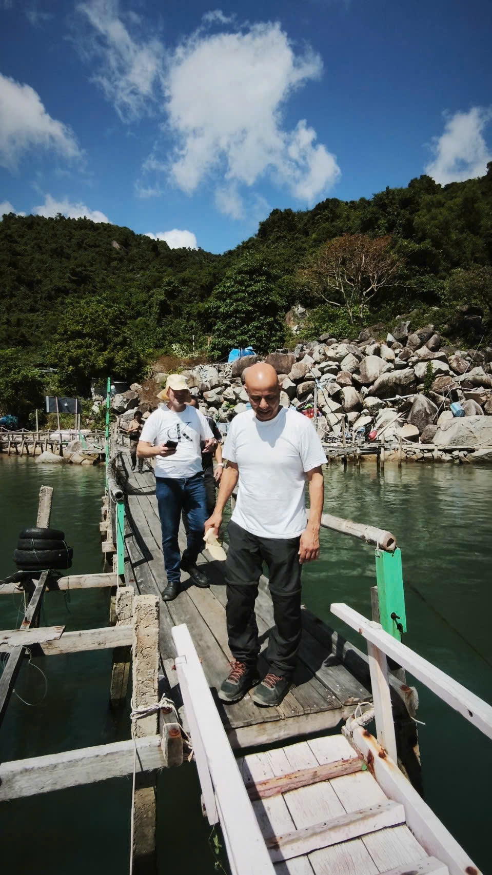 Riders walking along a wooden jetty in a bay