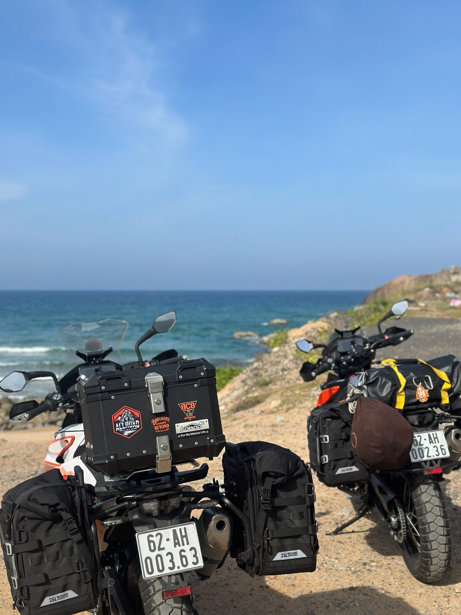 Loaded bikes parked on the coast facing the sea
