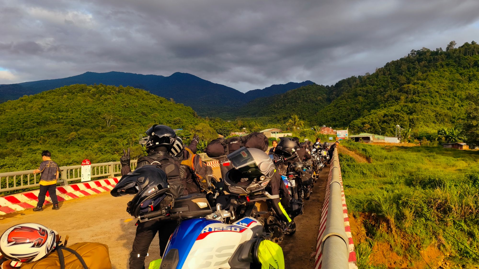 Bikes lined up on a bridge below forested mountains
