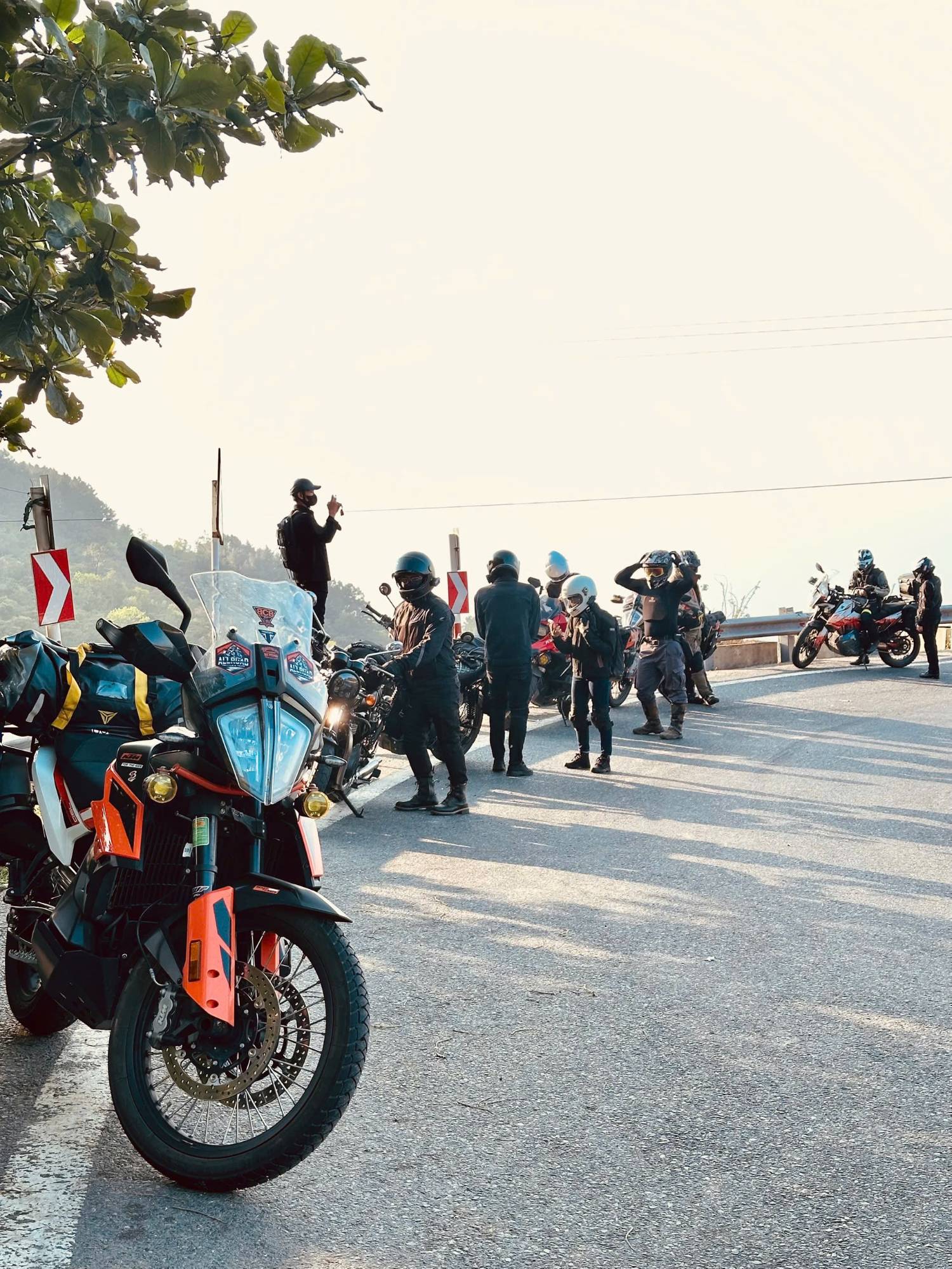 Group of riders stopped on a pass in the morning light