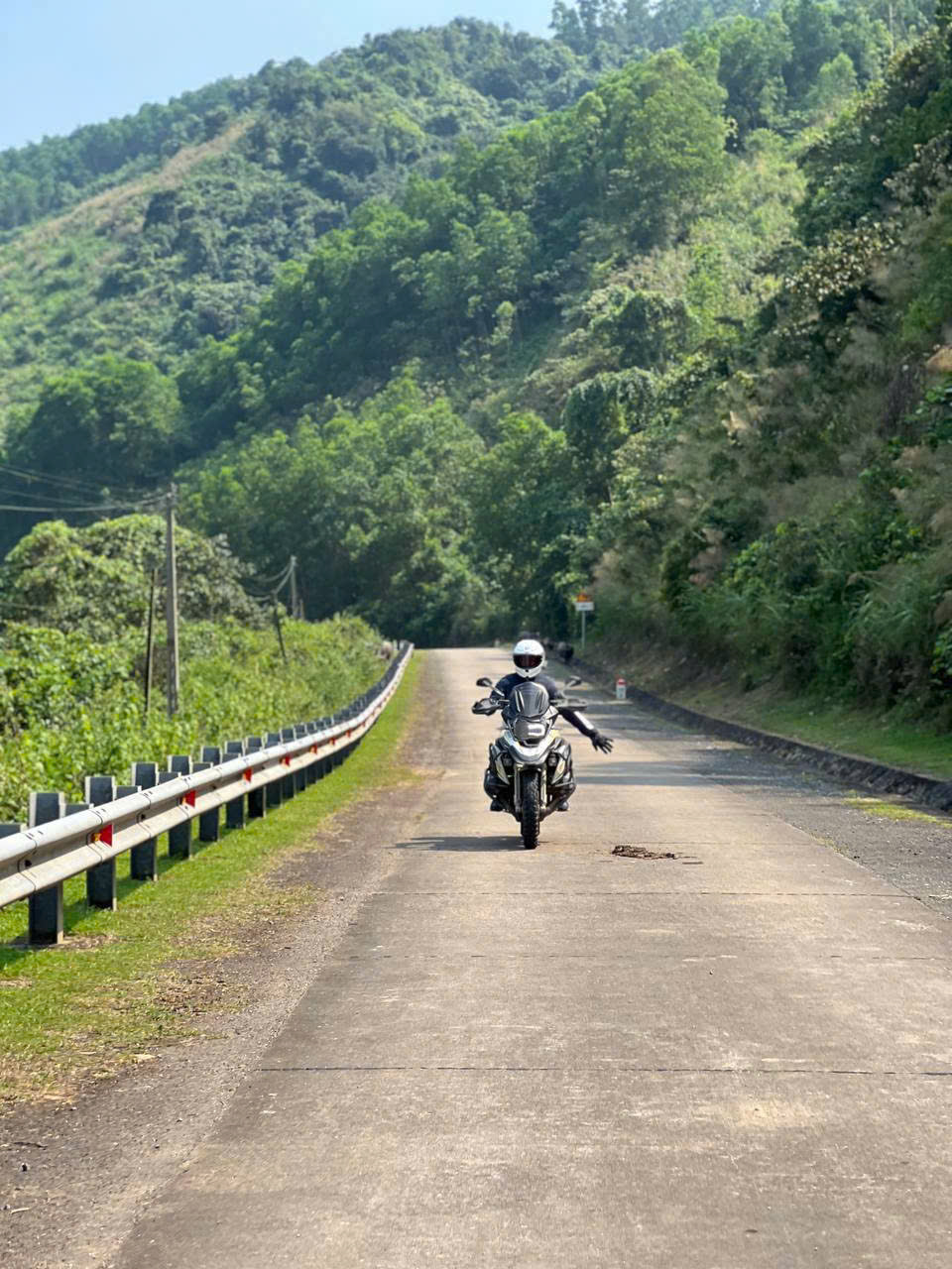 Rider waving on a quiet forest road