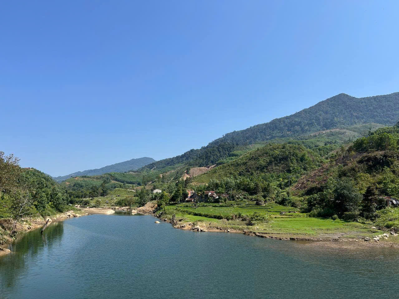 A river winding past rice fields and forested mountains in central Vietnam