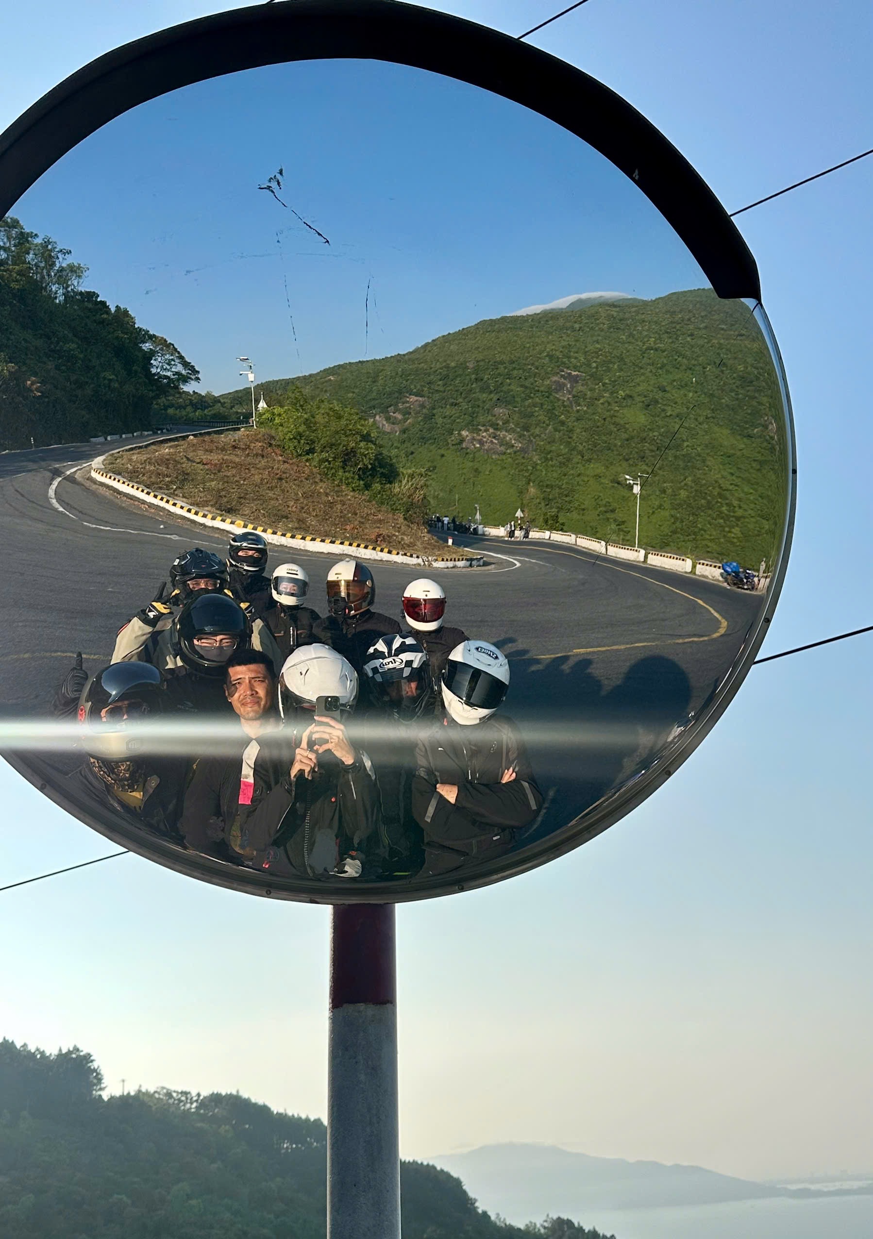The DME crew reflected in a road mirror on a mountain pass